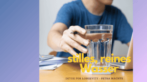 Mann greift zu Wasserglas. Sitzt am Bürotisch vor dem laptop