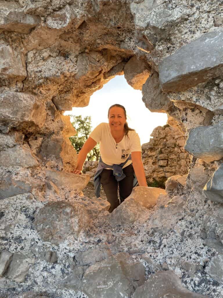 Petra blickt durch ein Loch eines Steingutes