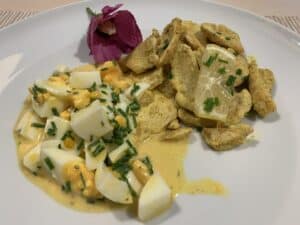 Weisser Teller mit Poulet-Curry- und Eiersalat