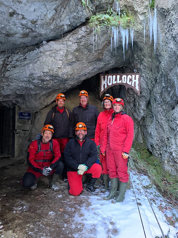 Gästegruppe vor dem Hölloch Höhleneingng, über ihnen hängen Eiszapfen