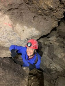 Petra kriecht in der Höhle durch eine Engstelle