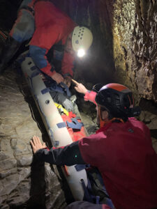 Übung mit echter Person in der Rettungsbarre in der Höhle