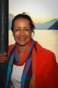 Petra lehnt an einem Laternensäule und im Hintergrund sieht man den Sonnenuntergang über dem Vierwaldstättersee.