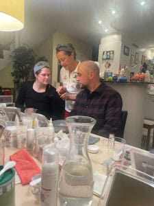 Petra mit zwei Menschen am Produkte ausprobieren und schmieren