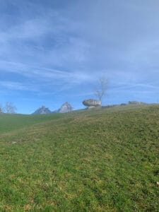 Der Druidenstein in Morschach. Erliegt auf einem Golfplatz und ist ein grosser Granitfindling. Im hintergrund die zwei Spitzen des kleinen und grossen Mythenberges.