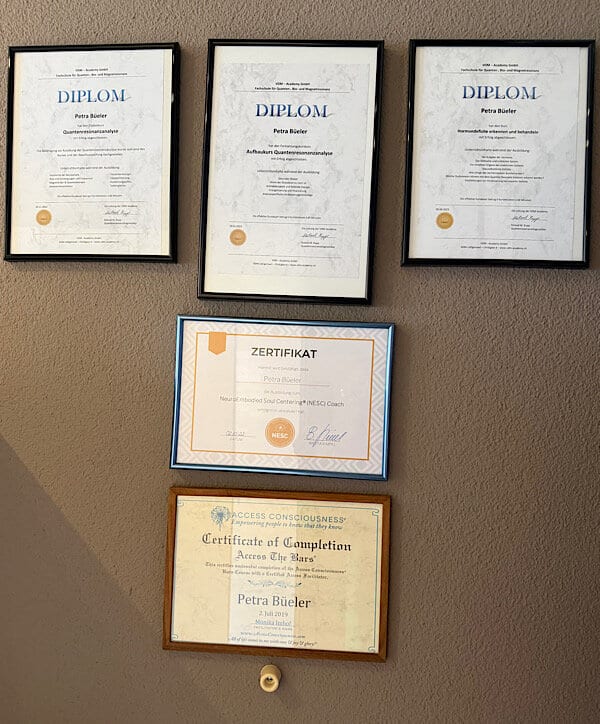 Zertifikat-Wand bei Petra zeigt: Quantenresonanzanalyse, NeuroEmbodiedSoulCentering (NESC) Coach, Access Conciousness Practitioner