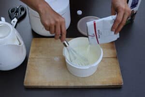 Joghurtpulver mit 4 Bakterienstämmen werden in Milch eingerührt