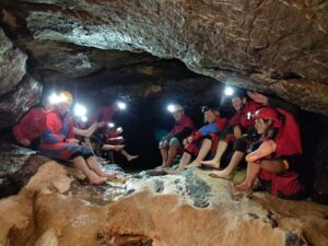 Höhlenführeraspiranten sitzen Barfuss in der Höhle im Sintergang